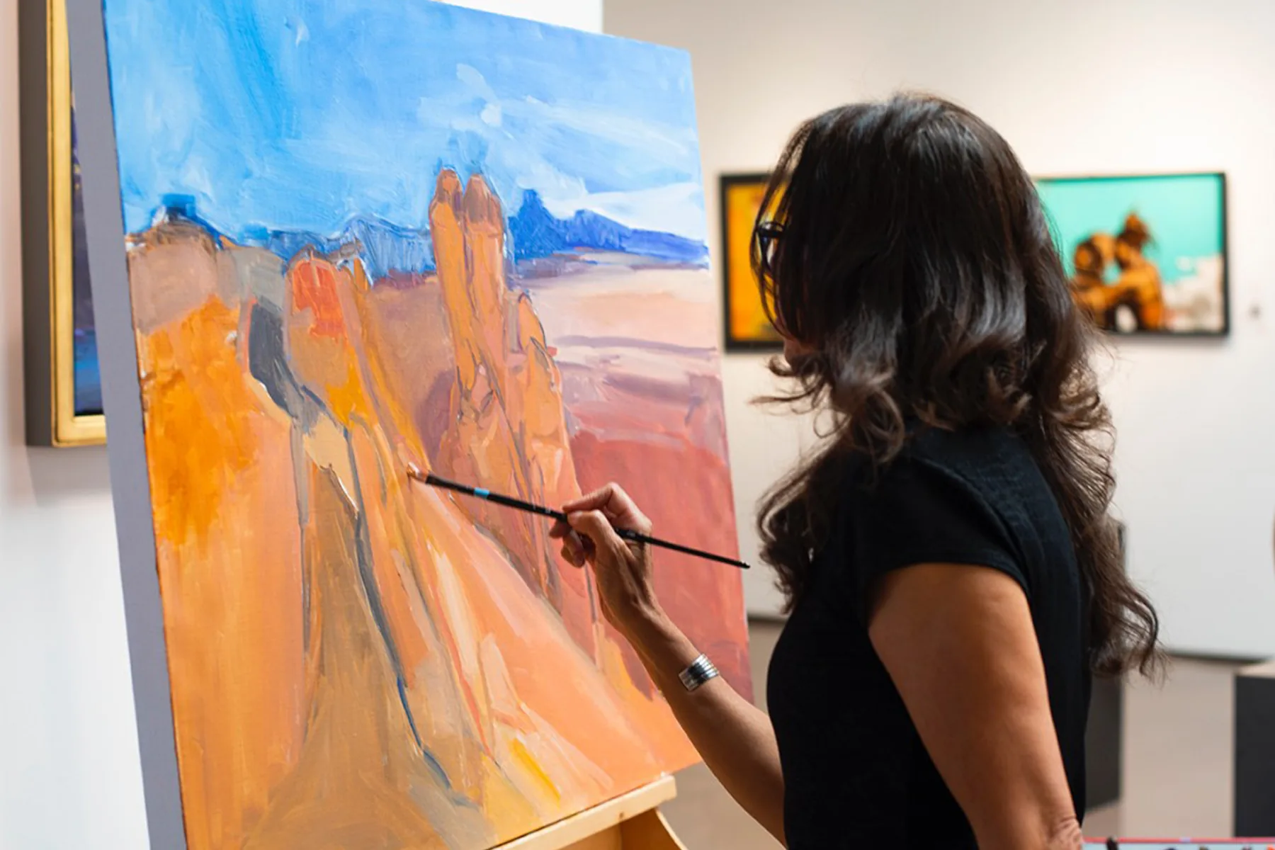 woman painting a desert landscape
